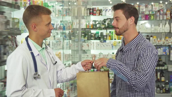Médico dando um pacote com pílulas para paciente — Fotografia de Stock