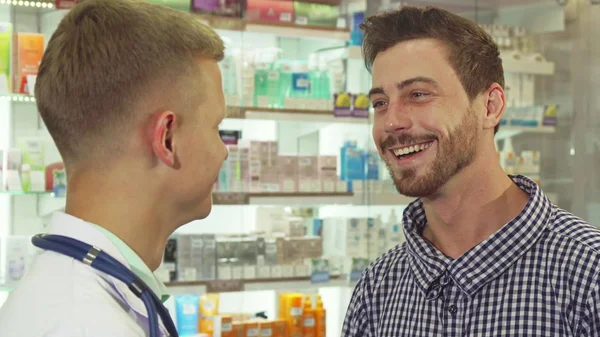 Пацієнт розмовляє з лікарем і сміється в аптеці — стокове фото