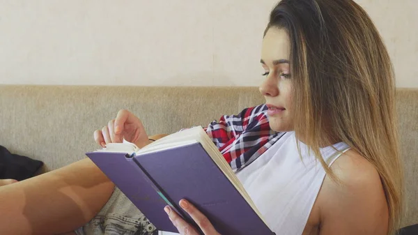 这个年轻的女孩正在读一本书 — 图库照片