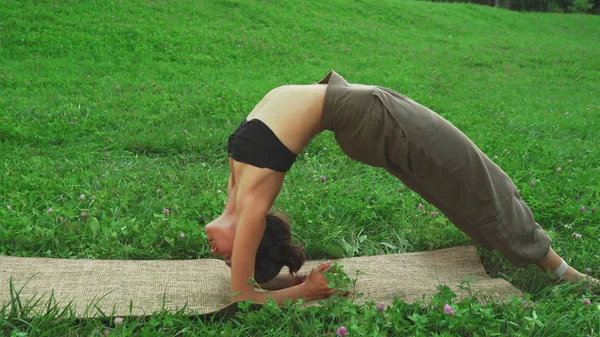 Chica está haciendo difícil yoga pose —  Fotos de Stock