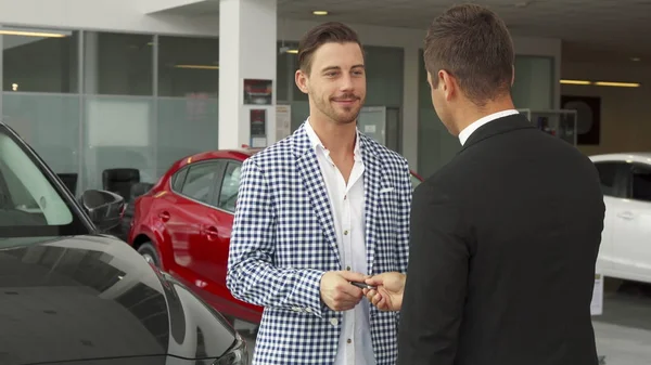 El comprador feliz y el vendedor hace un trato de comprar un coche — Foto de Stock