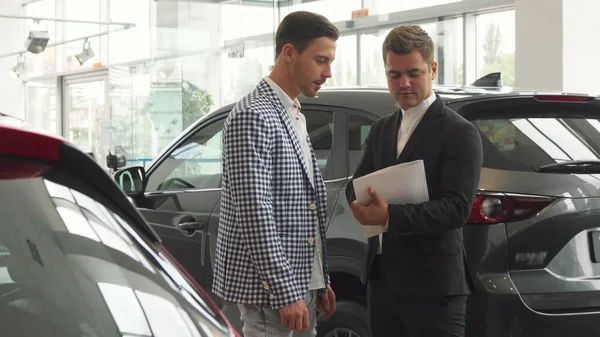 Los hombres serios firman un contrato de compra de coche — Foto de Stock