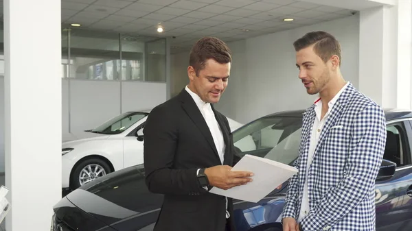 Potential buyer and seller read the characteristics of the car