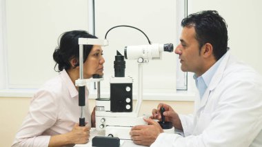 Yetenekli bir doktor hasta gözleri olan bir cihaz inceliyor.