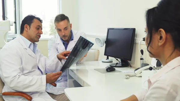 I medici esaminano i raggi X mentre sono seduti in ufficio — Foto Stock