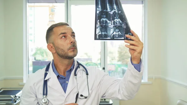 Продуманий лікар ретельно аналізує на рентгенівський знімок — стокове фото