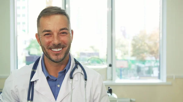 Médico sorridente examinando um tiro de um raio-X — Fotografia de Stock