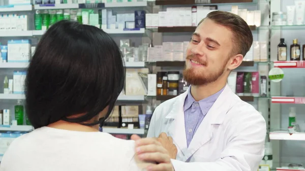 Um bom farmacêutico dá à mulher a sua compra. — Fotografia de Stock