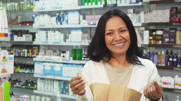 Cliente feliz olhando para um pacote com suas compras — Fotografia de Stock