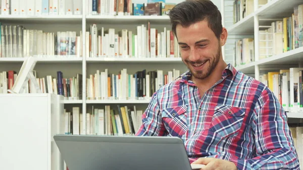 Glad kille ser på laptop och skrattar — Stockfoto