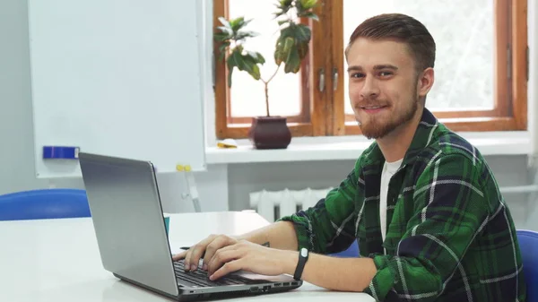 Ein junger Mann sitzt in einer Bildungseinrichtung am Computer — Stockfoto