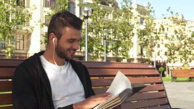 Mutlu bir adam bir şehir salonunda bir kitap okuyor