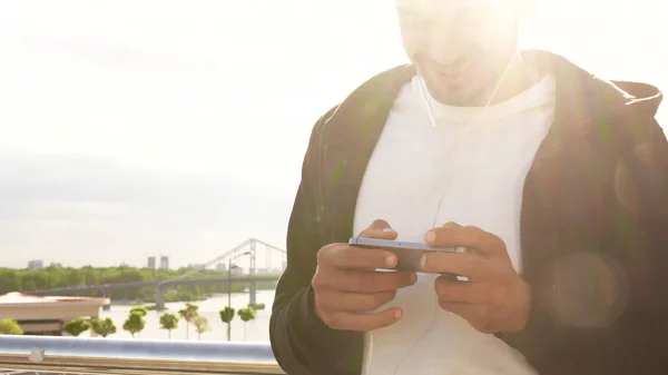 A young guy uses his mobile phone — Stock Photo, Image