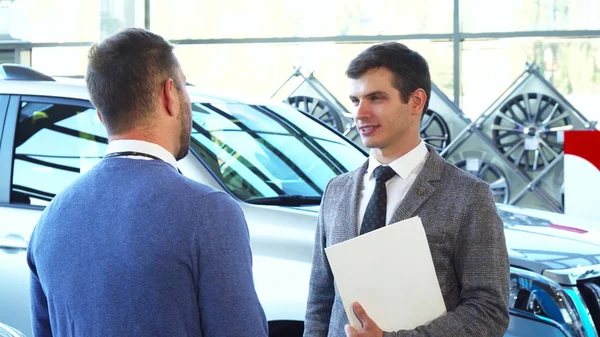 A representative seller gives the car keys to the buyer