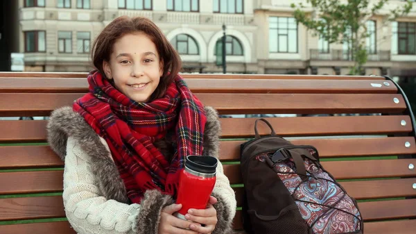 Маленькая девочка сидит на скамейке в большом городе — стоковое фото