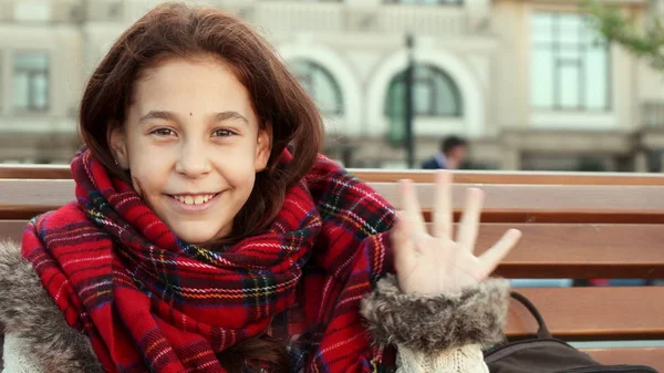 Menina feliz bebe uma bebida quente enquanto está sentado na rua — Fotografia de Stock