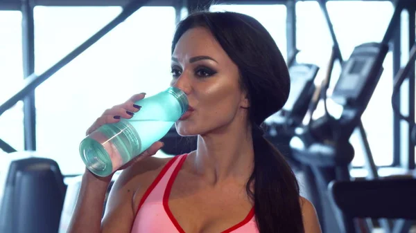 Lovely woman is drinking water in the gym — Stock Photo, Image
