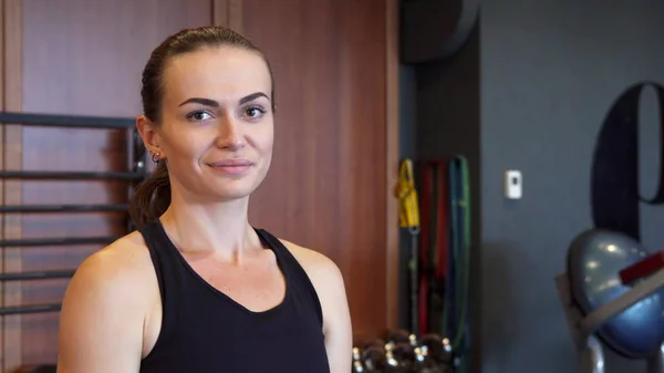 La joven está haciendo ejercicios en el gimnasio usando una mancuerna redonda especial — Foto de Stock