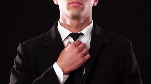 Крупный план рук парня, который выпрямляет галстук — стоковое фото
