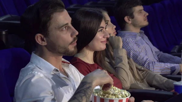 Cuatro amigos están sentados en la sala de cine y viendo la película —  Fotos de Stock