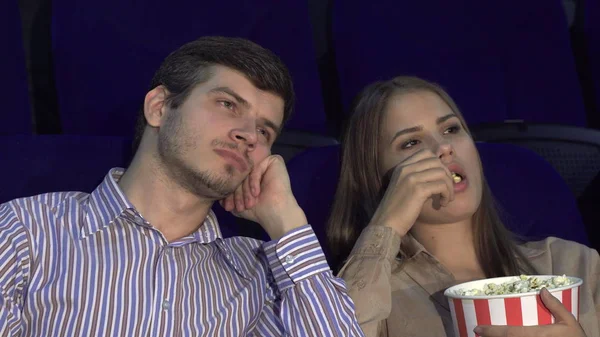 Bonito casal entediado enquanto assiste a um filme no cinema — Fotografia de Stock