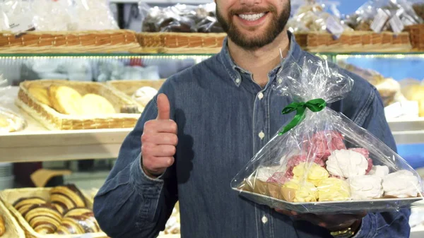 Обрезанный снимок счастливого бородатого мужчины, показывающего большие пальцы в пекарне — стоковое фото