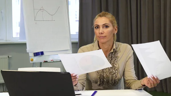 Mature business woman looking confused while examining documents — Stock Photo, Image