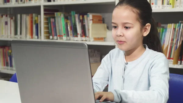 Милая маленькая азиатка учится работать на ноутбуке. — стоковое фото