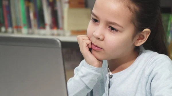 Menina bonito concentrando usando seu laptop — Fotografia de Stock