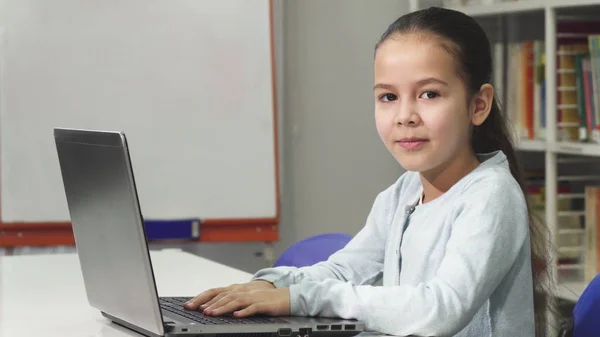 Feliz bela menina asiática sorrindo enquanto usa laptop — Fotografia de Stock