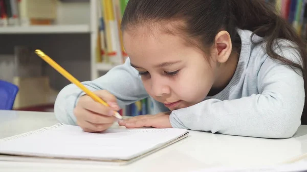 Adorable niña dibujando en su cuaderno —  Fotos de Stock