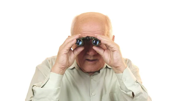 Viejo usando prismáticos mirando sorprendido a la cámara — Foto de Stock