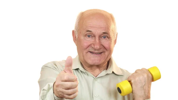 Gelukkig oude man met duimen omhoog uit te werken met een halter — Stockfoto