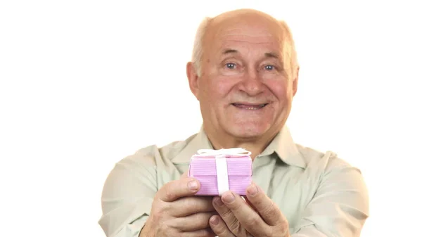 Feliz anciano sonriendo alegremente sosteniendo una caja de regalo a la cámara — Foto de Stock