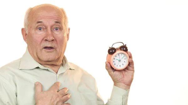 Hombre mayor mirando sorprendido comprobar la hora en el reloj despertador — Foto de Stock