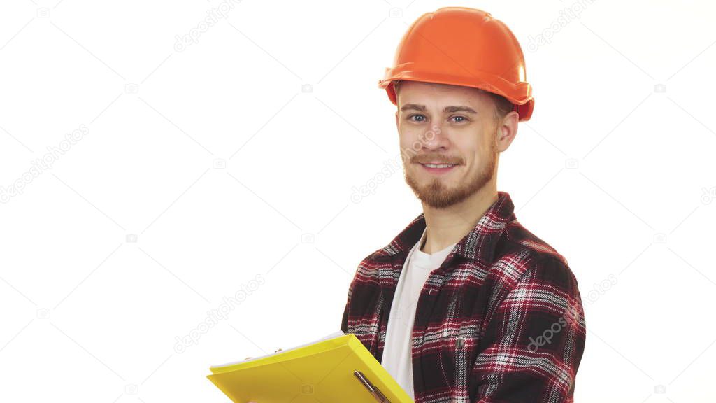 Young professional male contractor in hardhat making notes smiling