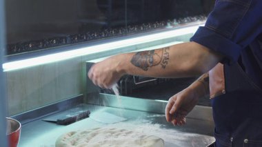 Yakışıklı erkek aşçı pişirme için hamur hazırlama