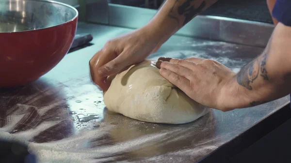 Professional baker preparing dough working at the kitchen