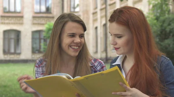 Female student points her forefinger into the journal outdoors — Stock Photo, Image