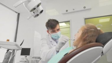 Sevimli küçük kız diş kontrolden sonra başparmak gösteren gülümseyen