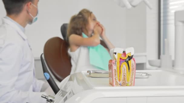 Ön planda çocuk ile çalışan diş hekimi sağlıksız diş modeli — Stok video