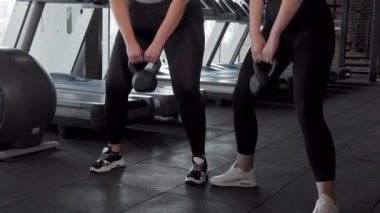 Spor salonunda kettlebell ile egzersiz iki artı boyutu sporcular sürgülü çekim