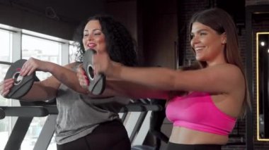 Güzel artı boyutu kadın spor salonunda arkadaşı ile çalışma