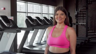 Mutlu güzel artı boyutu sporcu onu pazı kas esneme ve gülümseyen