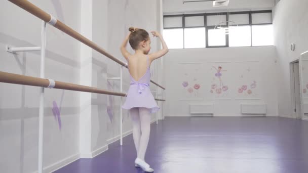 Прекрасна маленька балерина практикує її танці в балетній школі — стокове відео