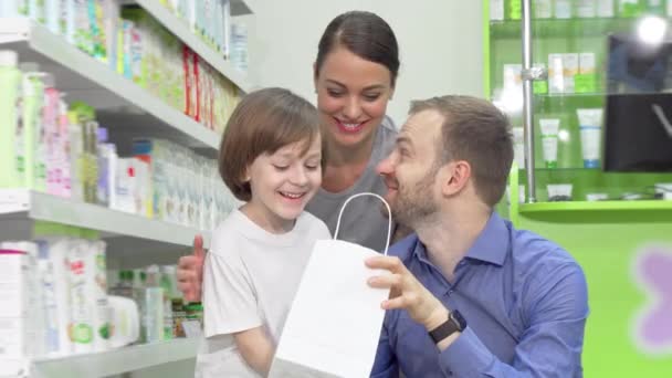 Mooie familie onderzoekt hun apotheek aankoop in een boodschappentas — Stockvideo