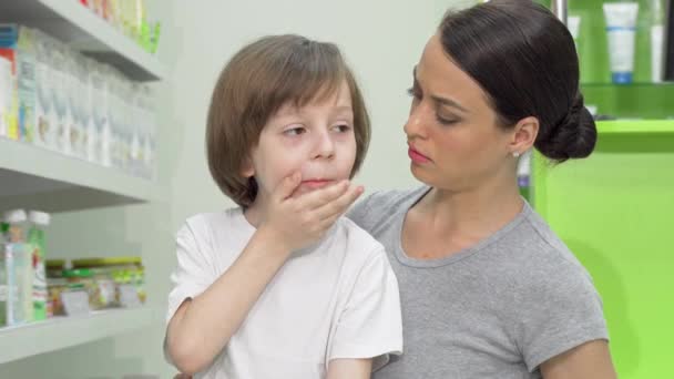 Schöne Frau sieht verstört aus, wie ihr kleiner Sohn hustet und Fieber hat — Stockvideo