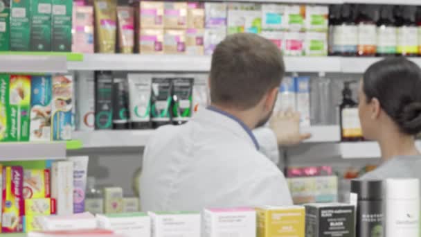 Mannelijke apotheker en zijn vrouwelijke klant bespreken van producten in de uitverkoop — Stockvideo