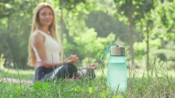 Nő meditál a parkban a fűben — Stock videók