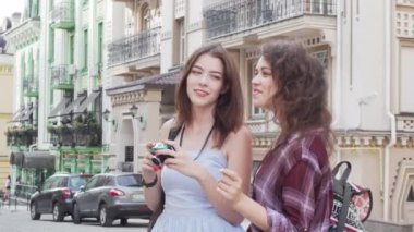 Birlikte seyahat ederken şehrin fotoğraflarını çeken iki güzel bayan arkadaş